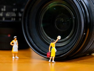 miniature woman housemaid cleaning Camera Lens