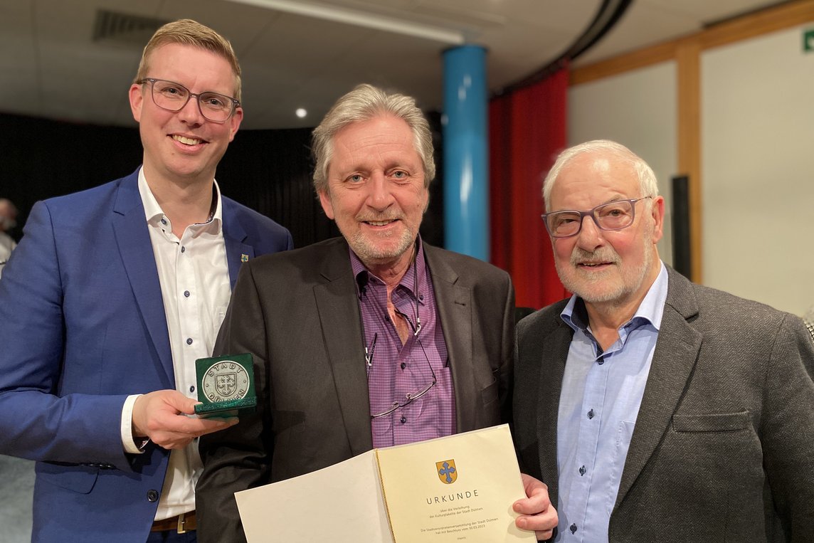 Bürgermeister Carsten Hövekamp (il.) überreichte die Kulturplakette an Georg Breitkopf (Mitte). Die Laudatio auf den Geehrten hielt Werner Schonrath. Foto: Stadt Dülmen/Kannacher