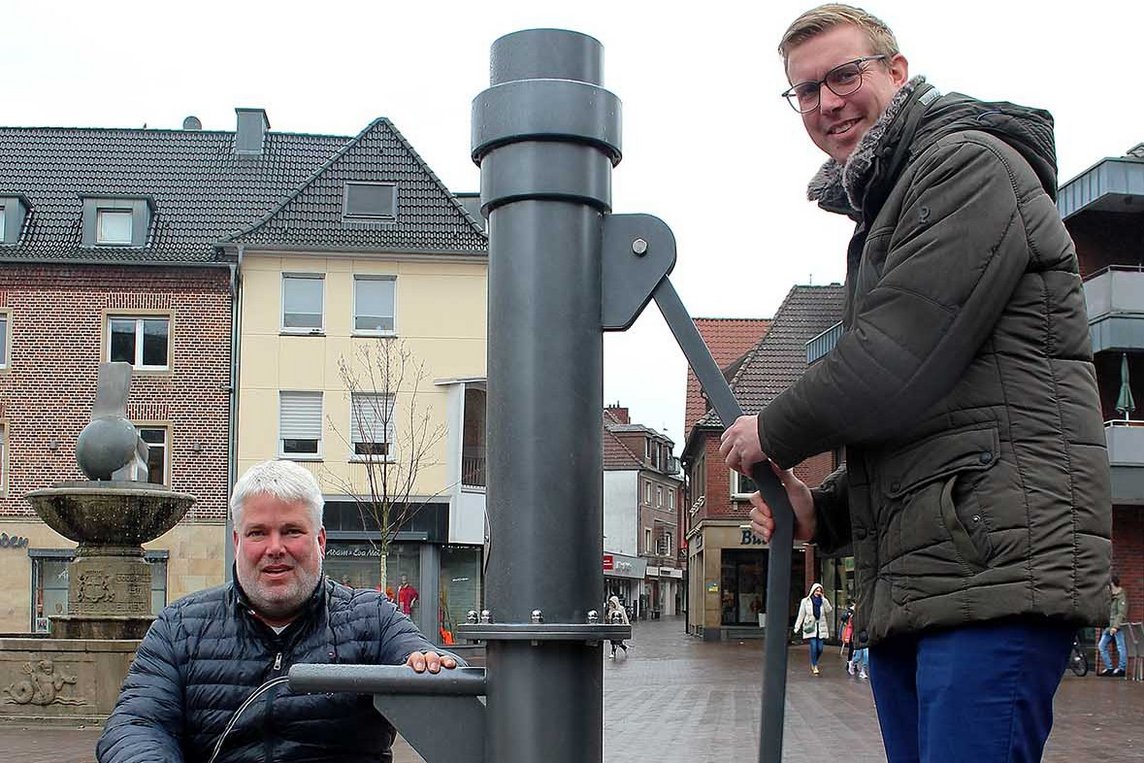 Dieses Foto zeigt Bürgermeister Carsten Hövekamp und Tiefbau-Mitarbeiter Ralf Brinkmann bei der Inbetriebnahme der neuen Schwengelpumpe.